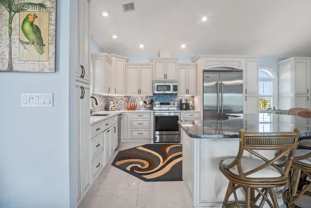 a kitchen with granite countertop white cabinets stainless steel appliances and a sink