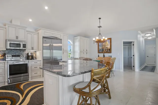 a living room with furniture a ceiling fan and a large window