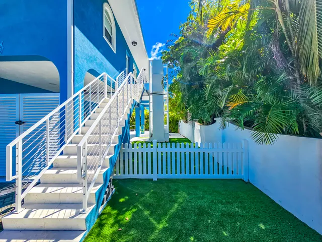 a kitchen with stainless steel appliances kitchen island granite countertop a dining table chairs and a refrigerator