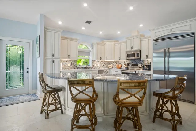 a kitchen with white cabinets and sink