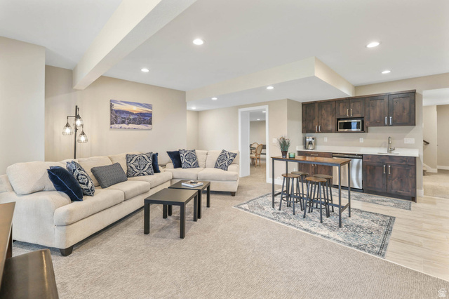 4527 North Seven Bridges Road Eden, UT 84310 - Photo 34 of 65 Living area with light colored carpet, beam ceiling, recessed lighting, and bar with sink