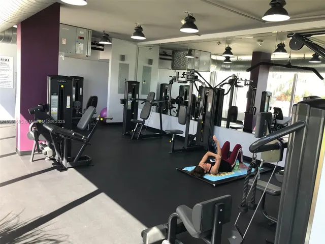 a room with gym equipment and large mirror