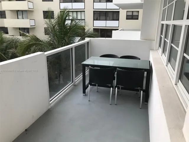 a view of a balcony with table and chairs