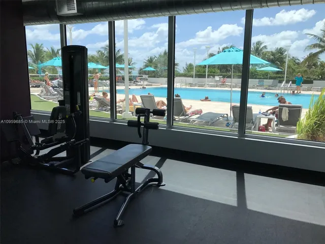 a room with gym equipment and large windows