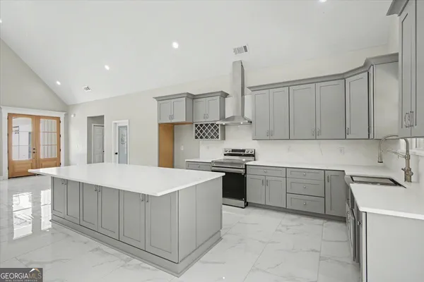 a kitchen with kitchen island granite countertop a sink stove and cabinets