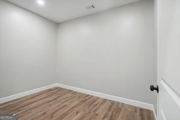 a view of empty room with wooden floor