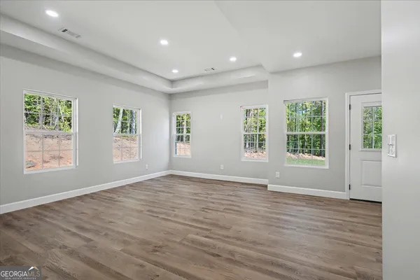 an empty room with wooden floor and windows