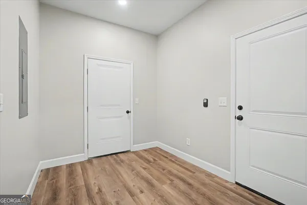 an empty room with wooden floor and windows
