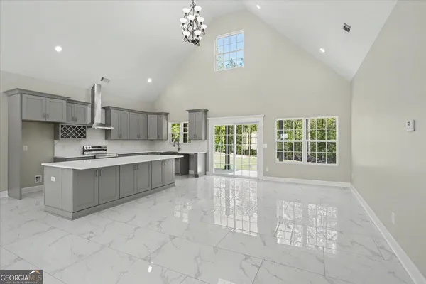 a large kitchen with kitchen island white cabinets and stainless steel appliances