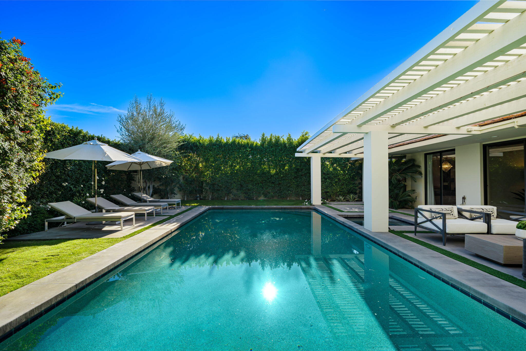 6 Exeter Court Rancho Mirage, CA 92270 - Photo 32 of 54 a view of swimming pool with lawn chairs under an umbrella