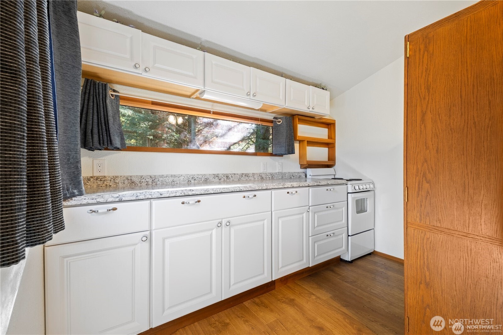 14310 200th Avenue Southeast Renton, WA 98058 - Photo 13 of 39 a kitchen with granite countertop white cabinets and a wooden floor