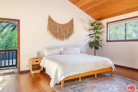 a bedroom with a bed and a large mirror next to a window