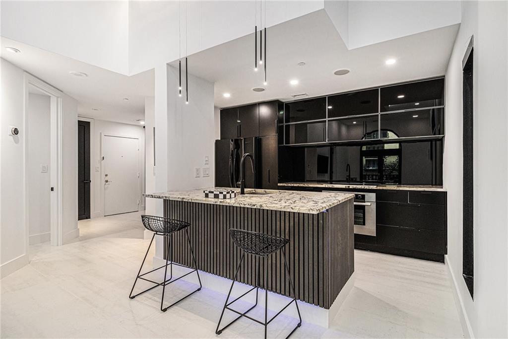199 14th Street Northeast, Unit 103 Atlanta, GA 30309 - Photo 11 of 32 a view of kitchen island with cabinets and refrigerator