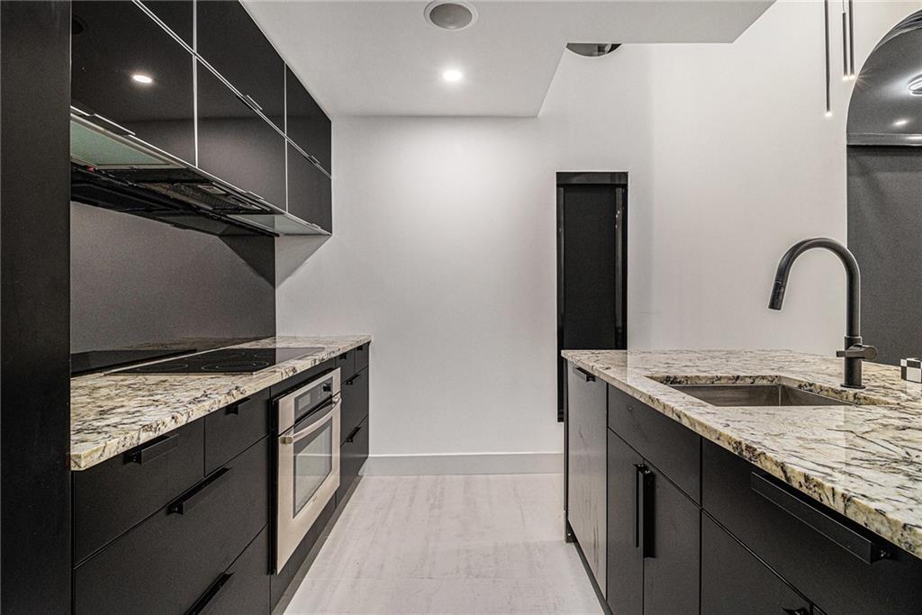 199 14th Street Northeast, Unit 103 Atlanta, GA 30309 - Photo 13 of 32 a kitchen with stainless steel appliances granite countertop a stove a sink and a microwave