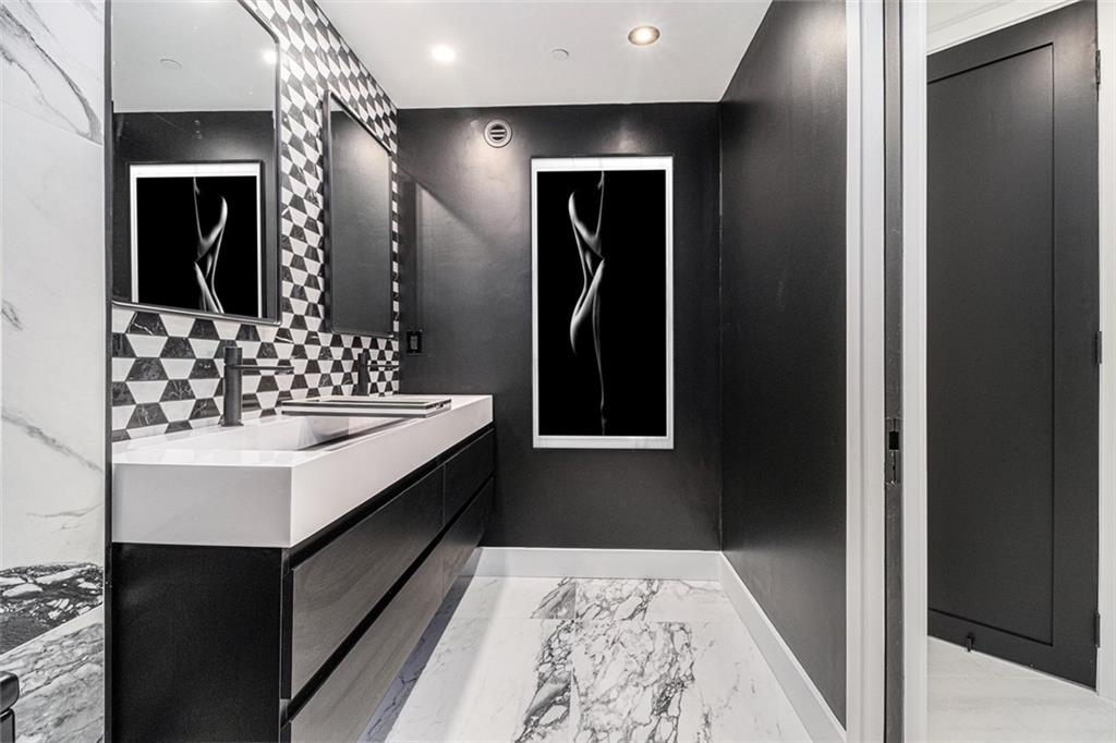 199 14th Street Northeast, Unit 103 Atlanta, GA 30309 - Photo 14 of 32 a bathroom with a sink and a mirror