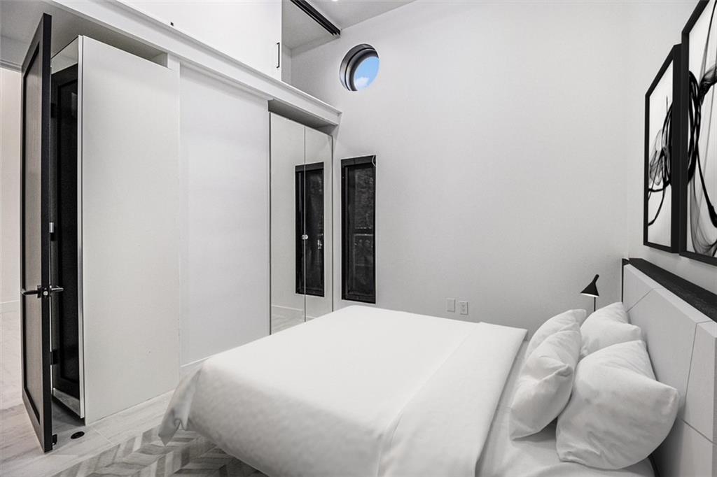 199 14th Street Northeast, Unit 103 Atlanta, GA 30309 - Photo 17 of 32 a bedroom with a bed and a mirror