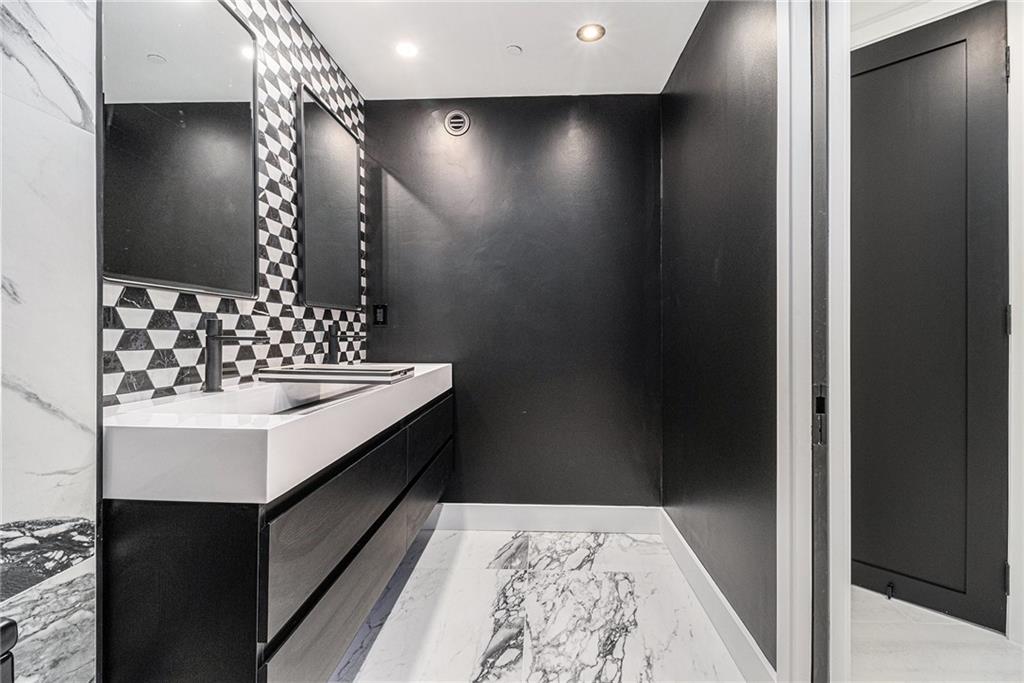 199 14th Street Northeast, Unit 103 Atlanta, GA 30309 - Photo 20 of 32 a bathroom with a sink and a mirror