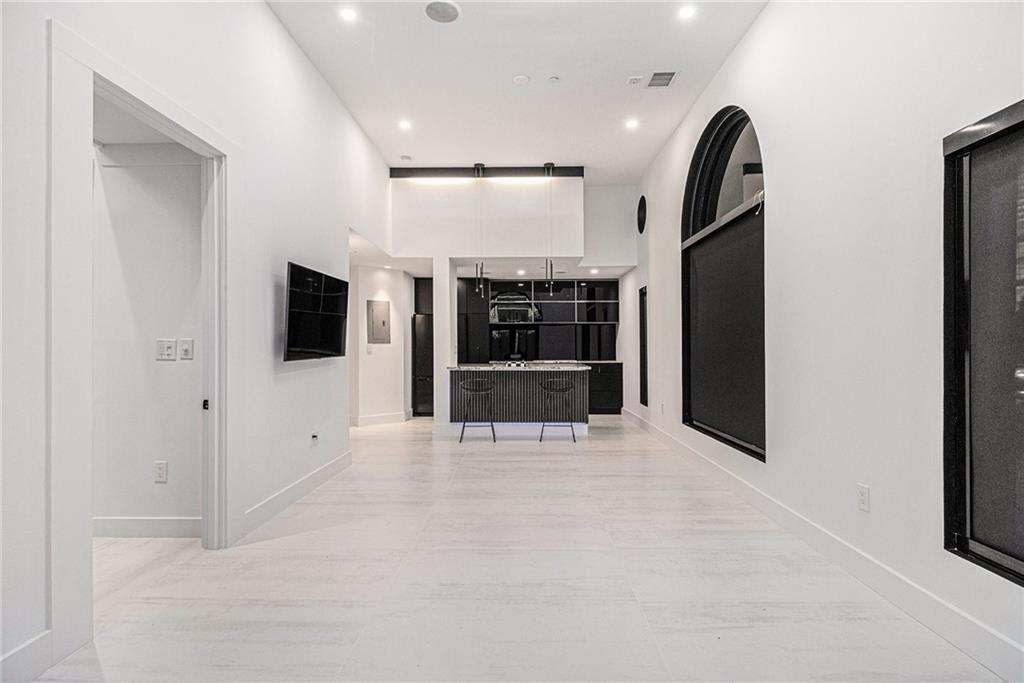 199 14th Street Northeast, Unit 103 Atlanta, GA 30309 - Photo 3 of 32 a view of an empty room with a flat screen tv and kitchen view