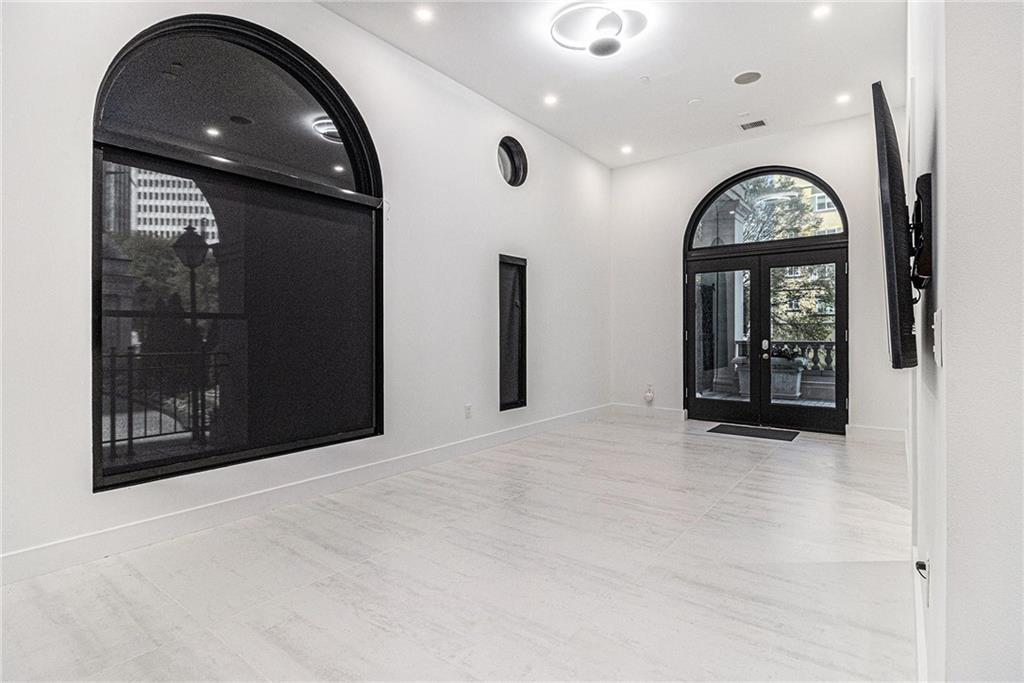 199 14th Street Northeast, Unit 103 Atlanta, GA 30309 - Photo 4 of 32 an empty room with entrance and mirror