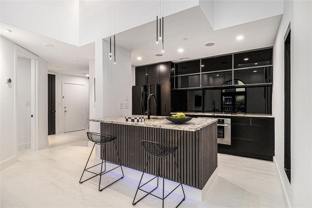 199 14th Street Northeast, Unit 103 Atlanta, GA 30309 - Photo 10 of 32 a kitchen with stainless steel appliances kitchen island granite countertop a sink and cabinets