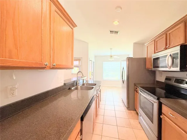 a kitchen with granite countertop a sink and a stove top oven