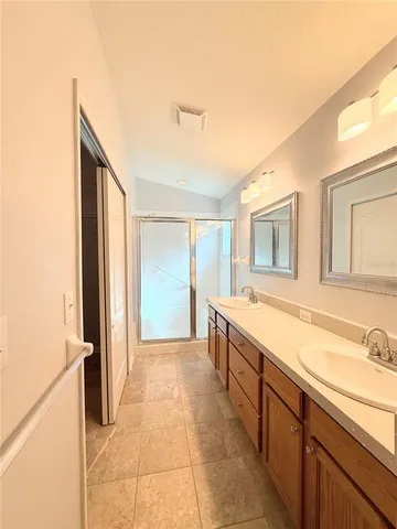 a spacious bathroom with a granite countertop sink a mirror and a shower