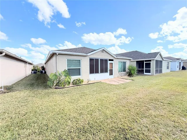 a view of a house with a yard and potted plants