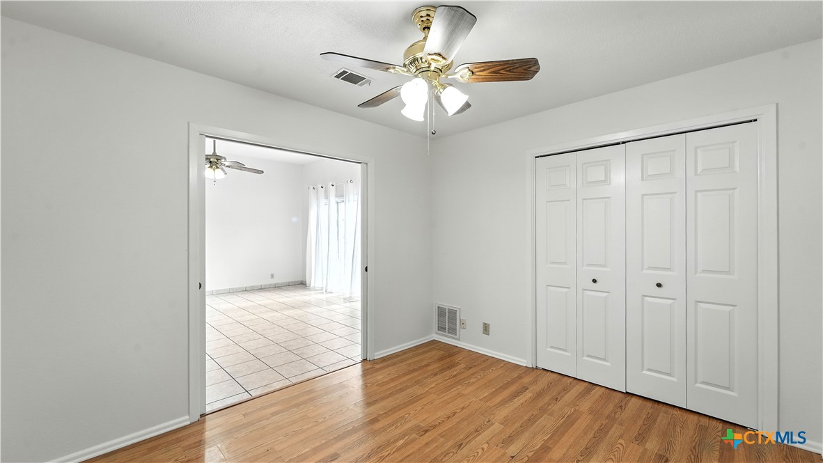8 Oak Villa Road, Unit G2 Canyon Lake, TX 78133 - Photo 12 of 17 an empty room with wooden floor and a ceiling fan