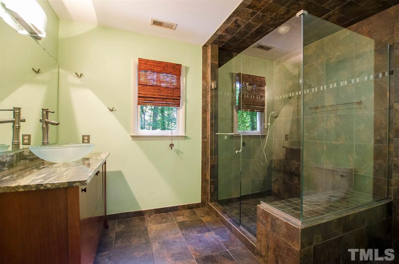 6205 Lookout Loop Raleigh, NC 27612 - Photo 11 of 25 a bathroom with a granite countertop sink a mirror and shower