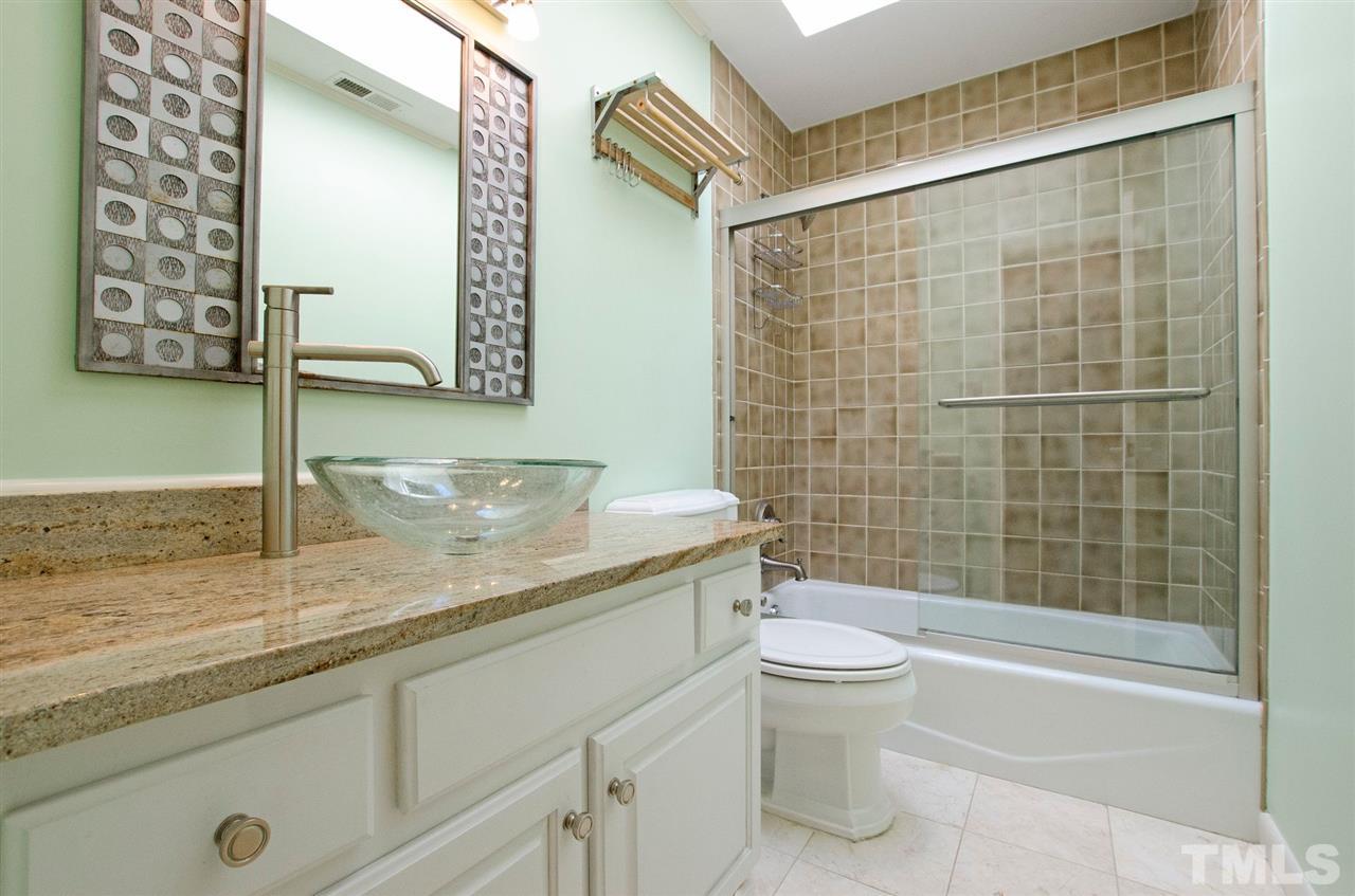 6205 Lookout Loop Raleigh, NC 27612 - Photo 15 of 25 a bathroom with a granite countertop sink a toilet and shower