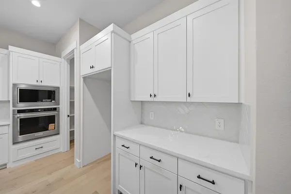 a kitchen with white cabinets and white appliances