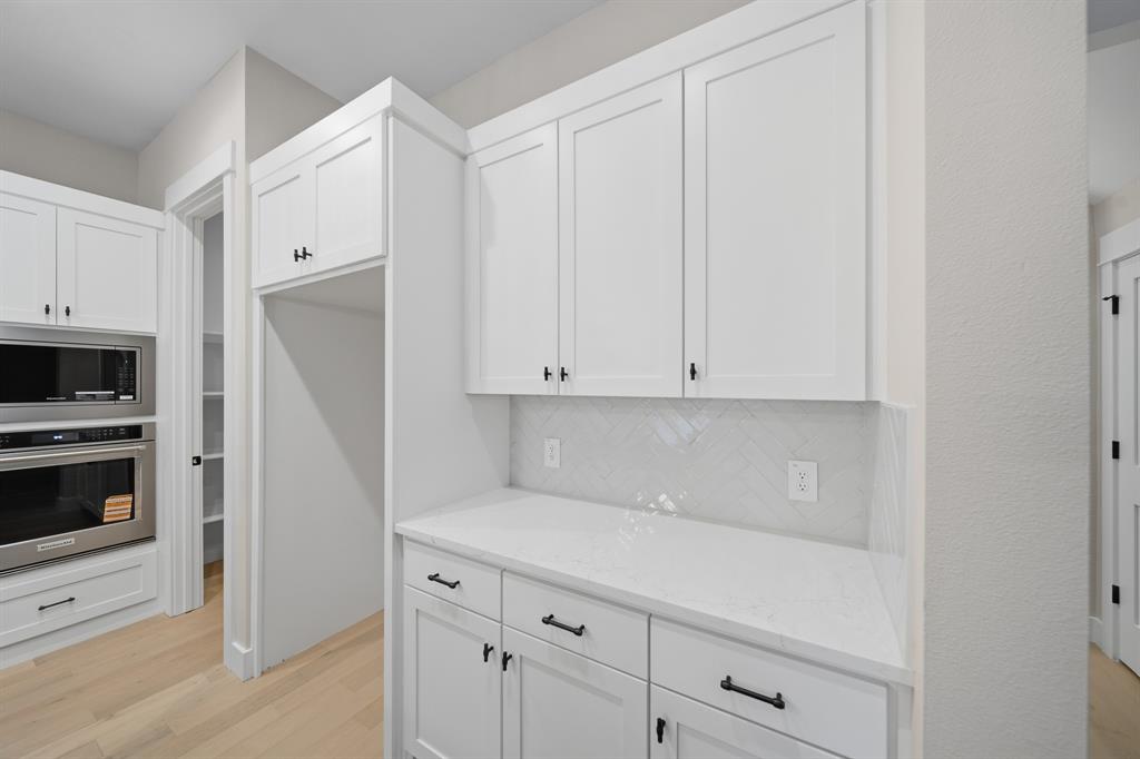 1902 Pebble Lane Rockwall, TX 75087 - Photo 22 of 35 a kitchen with white cabinets and white appliances