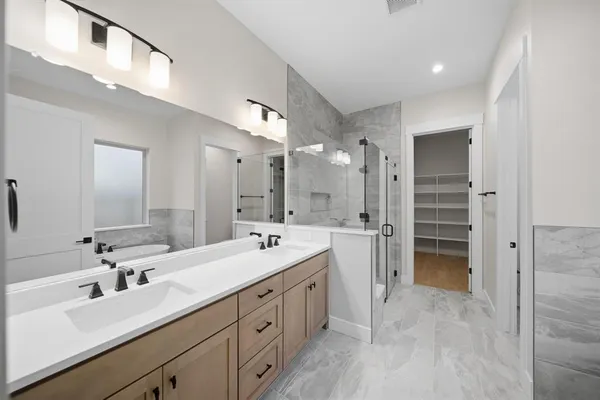 a bathroom with a sink mirror and shower