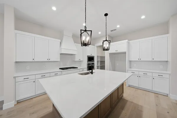 a view of kitchen and kitchen with stainless steel appliances wooden floor