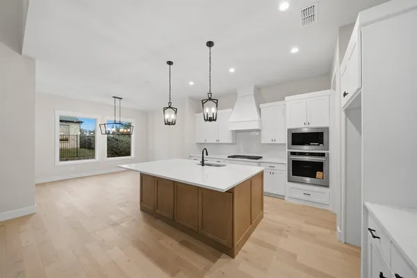 a kitchen with a sink and stove top oven