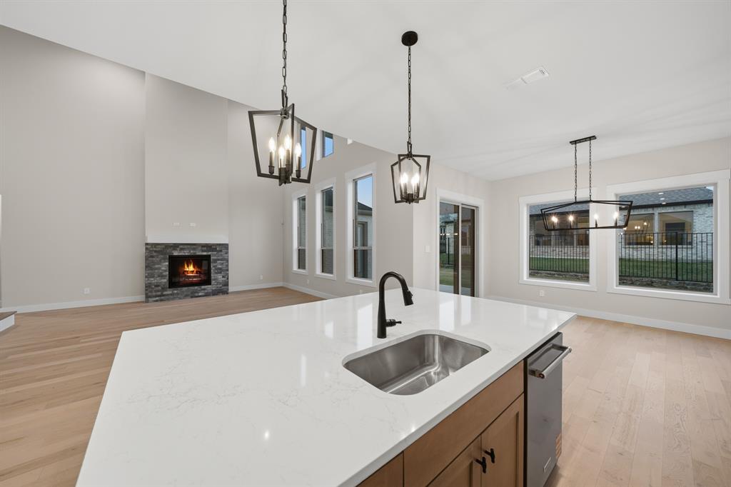 1902 Pebble Lane Rockwall, TX 75087 - Photo 9 of 35 a kitchen with stainless steel appliances a sink a chandelier and wooden floor