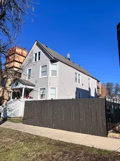 a view of a house with a wooden fence