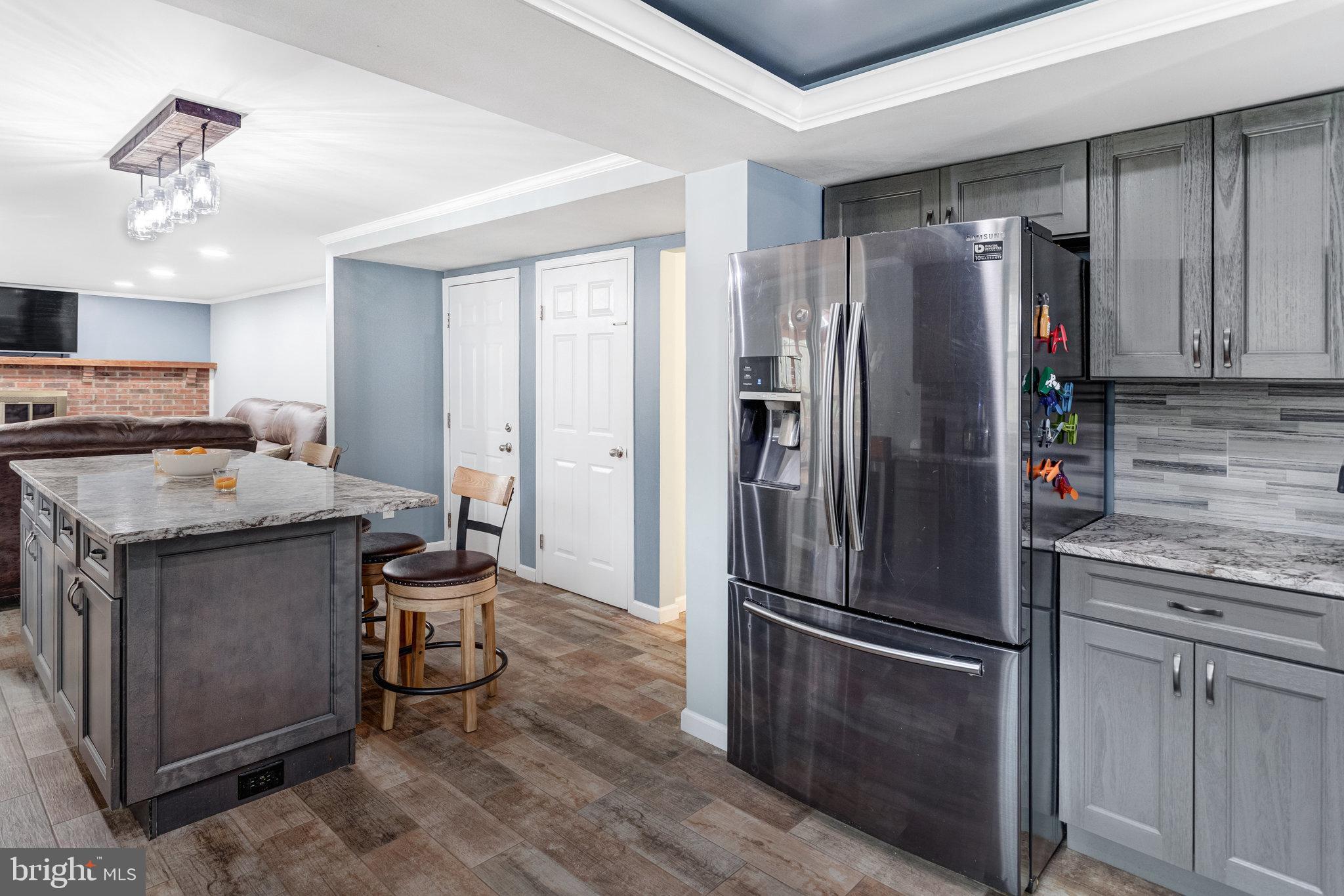 4586 Rincon Place Dumfries, VA 22025 - Photo 11 of 46 a kitchen with granite countertop stainless steel appliances a refrigerator a stove a sink cabinets and living room view