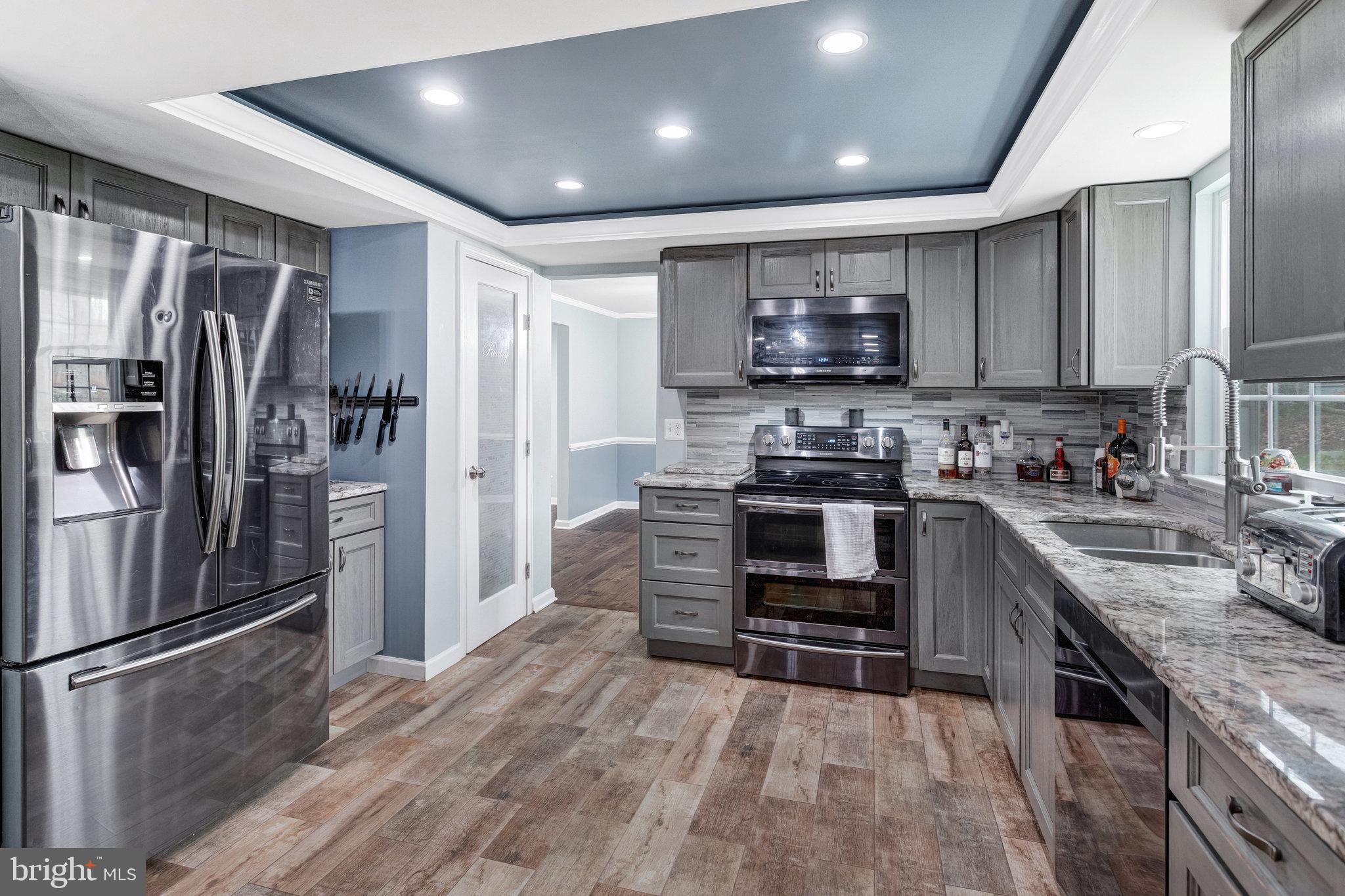 4586 Rincon Place Dumfries, VA 22025 - Photo 12 of 46 a kitchen with kitchen island a counter top space stainless steel appliances and cabinets
