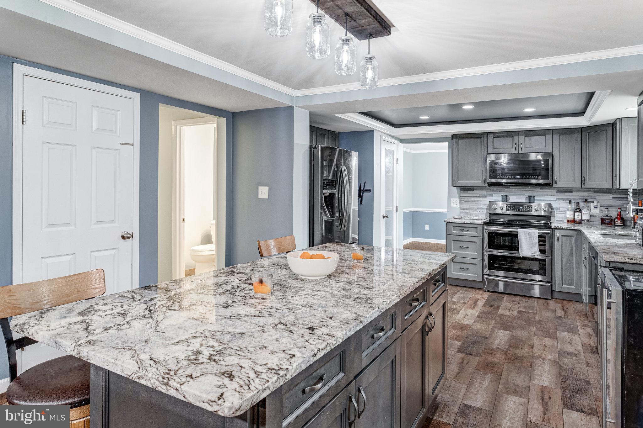 4586 Rincon Place Dumfries, VA 22025 - Photo 14 of 46 a kitchen with kitchen island granite countertop a sink and counter space