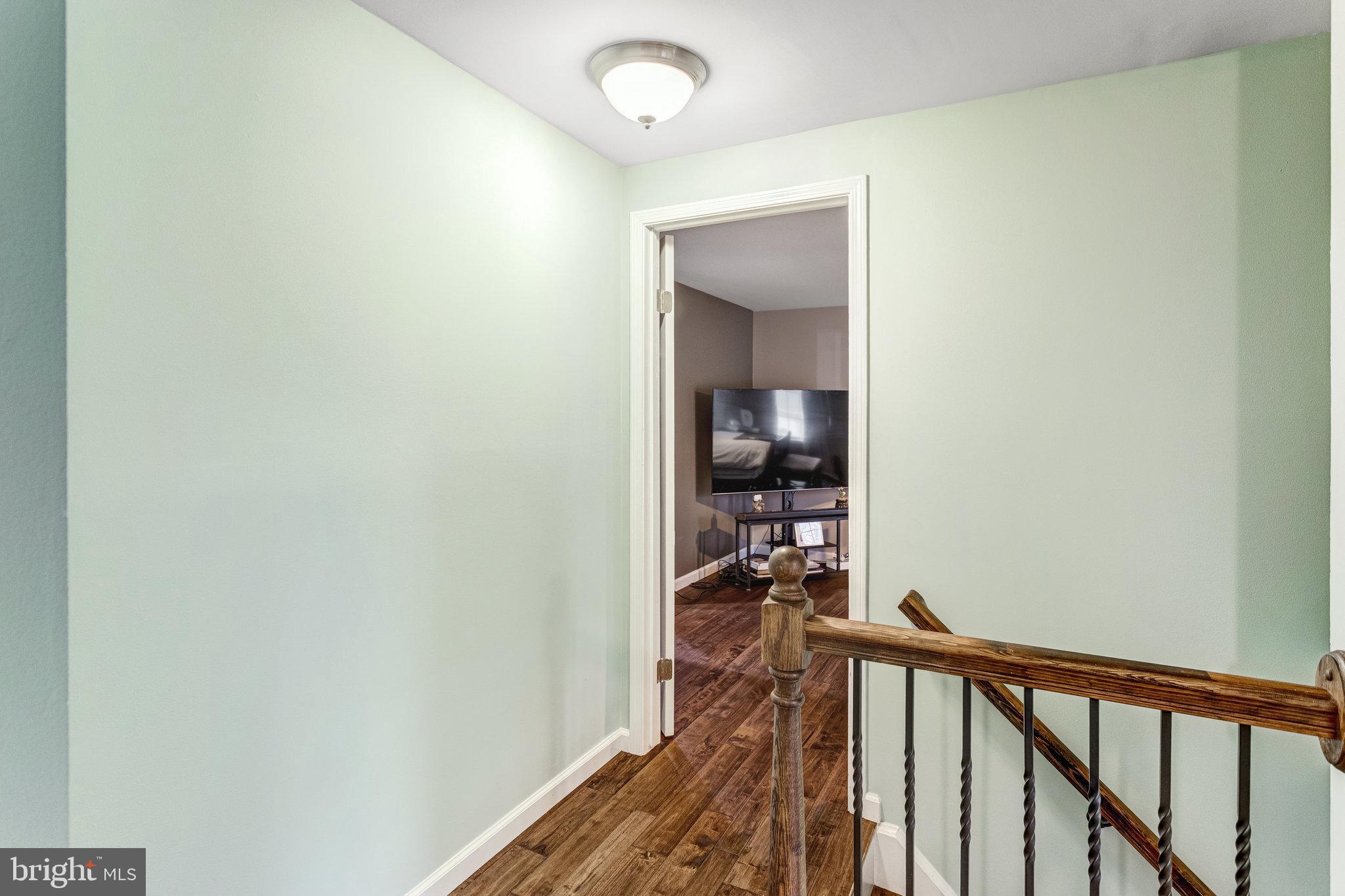 4586 Rincon Place Dumfries, VA 22025 - Photo 19 of 46 a view of a hallway with wooden floor and a bathroom