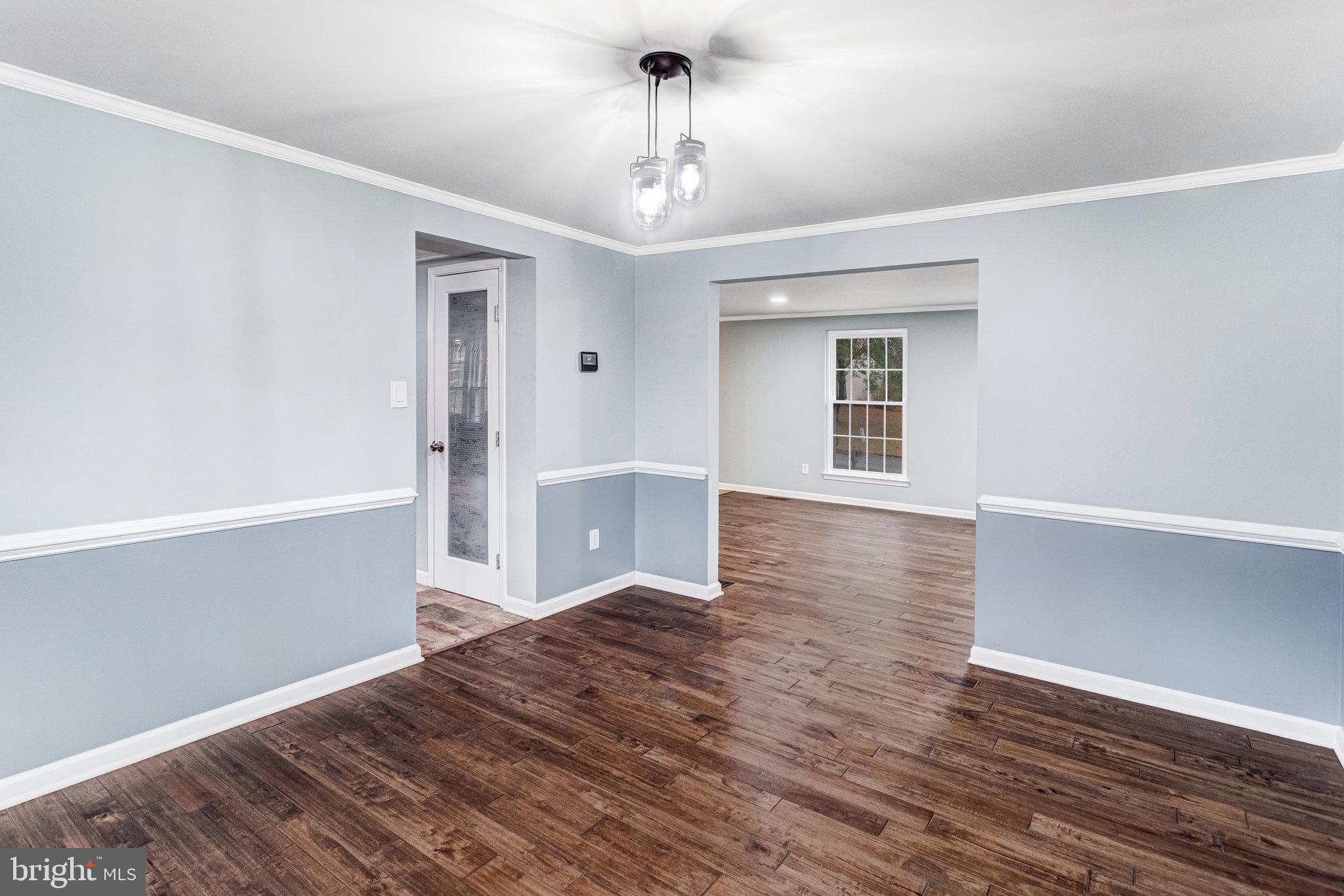 4586 Rincon Place Dumfries, VA 22025 - Photo 9 of 46 a view of a hallway with wooden floor and a chandelier