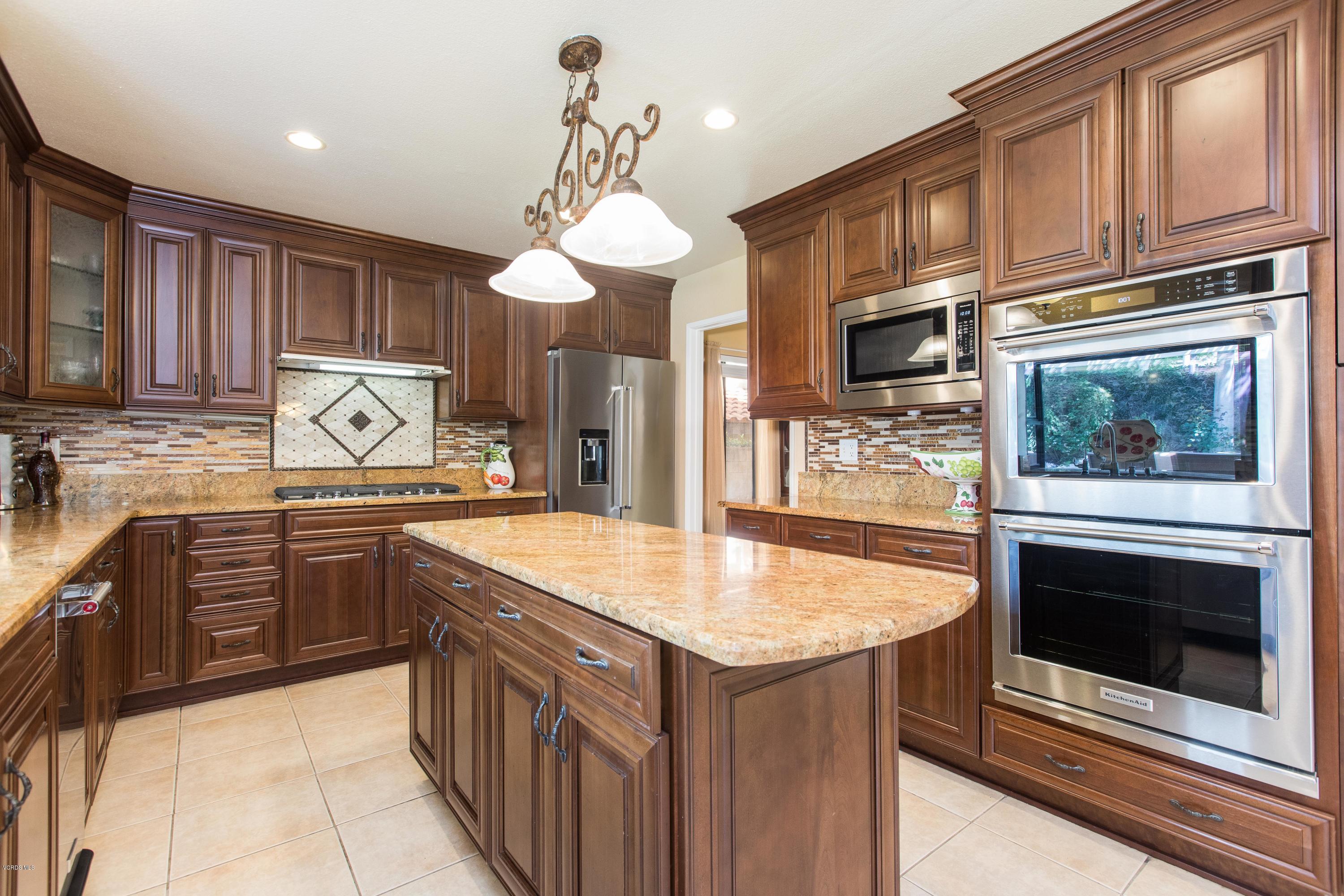4034 Doneva Road Moorpark, CA 93021 - Photo 2 of 47 a kitchen with stainless steel appliances granite countertop a stove top oven a sink dishwasher and a microwave oven with large wooden cabinets