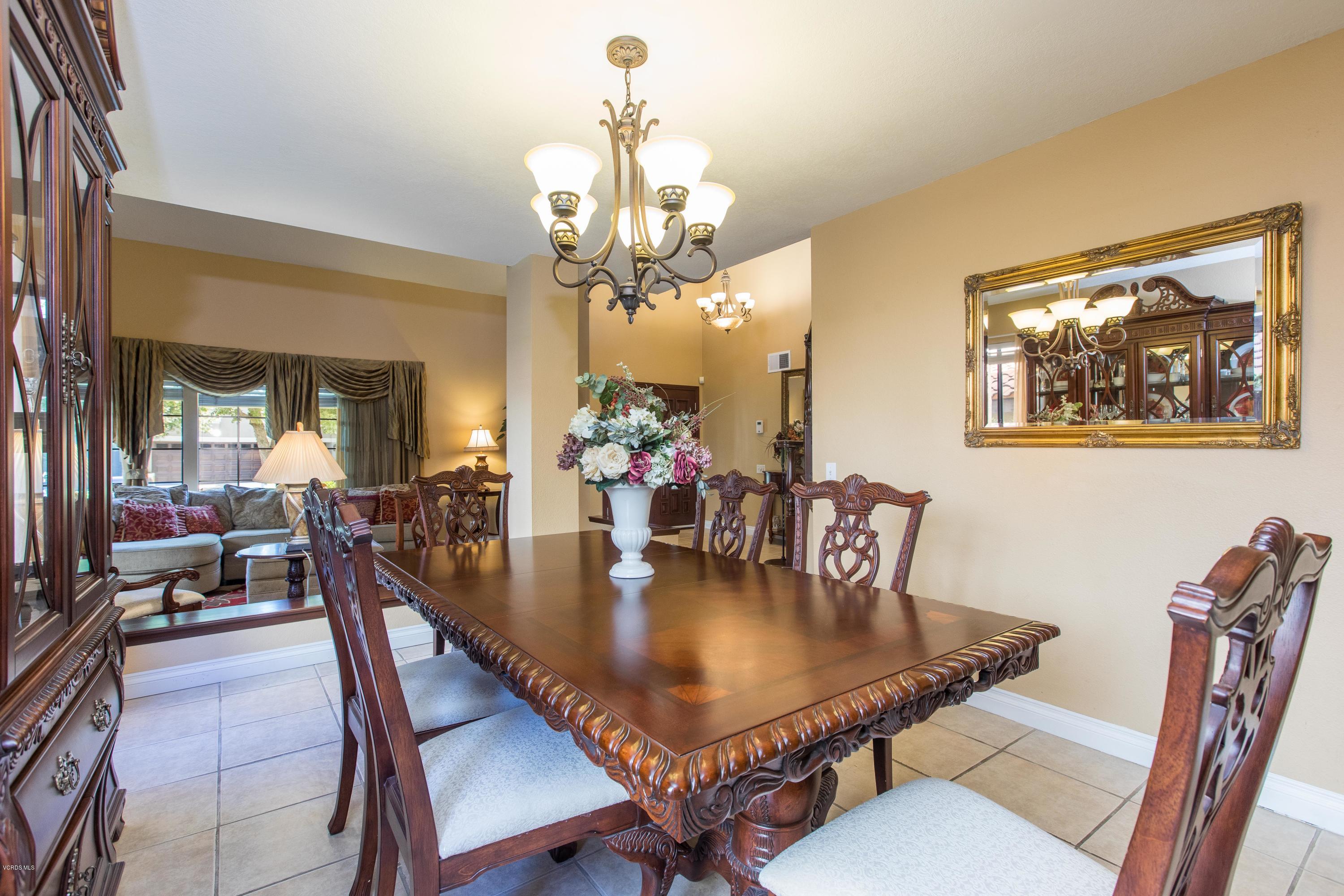 4034 Doneva Road Moorpark, CA 93021 - Photo 25 of 47 a dining room with wooden floor a chandelier a wooden table and chairs