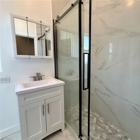 a bathroom with a sink a mirror and shower