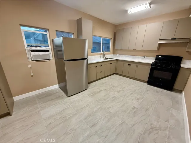 a kitchen with a refrigerator sink and cabinets
