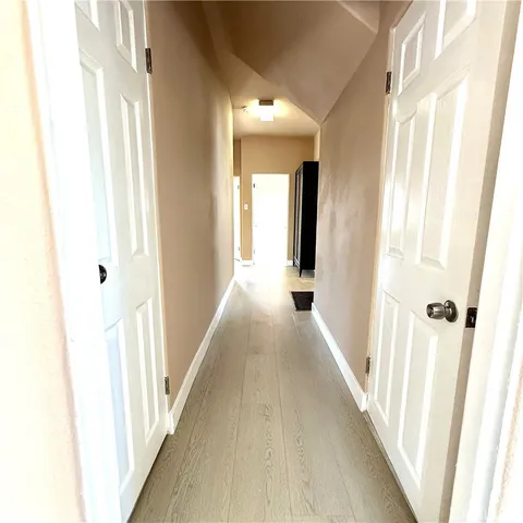 a view of a hallway with wooden floor and staircase