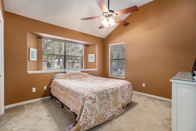 a bedroom with a large bed and a ceiling fan