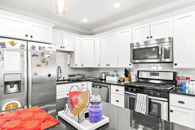 a kitchen with stainless steel appliances a stove a sink and a refrigerator