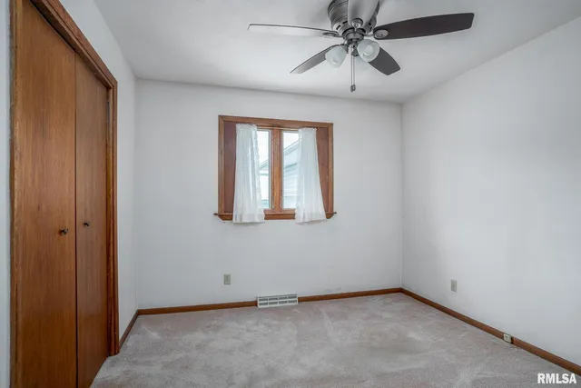 an empty room with chandelier fan